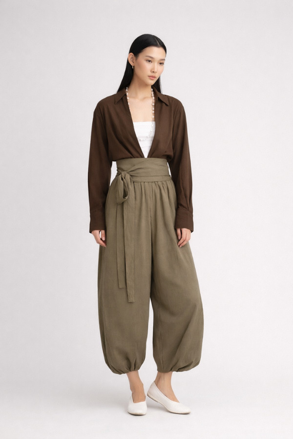 Woman wearing a brown drop-V neckline, relaxed loose-fit long-sleeve top paired with moss-green tobi pants.