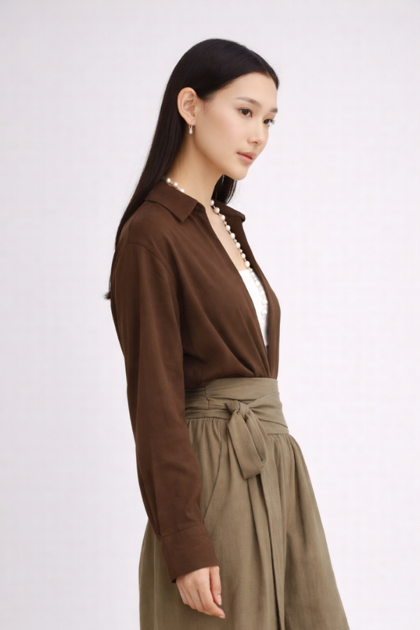 Woman wearing a brown drop-V neckline, relaxed loose-fit long-sleeve top paired with moss-green tobi pants.