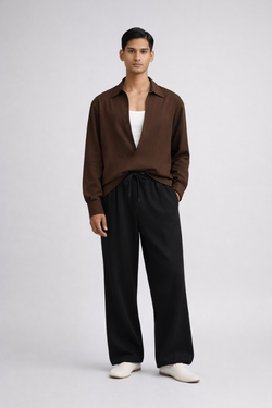 Man wearing a brown drop-V neckline, relaxed loose-fit long-sleeve top paired with black joggers